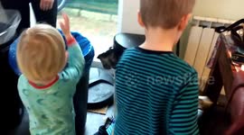 Two small boys helping mummy to separate waste for recycling at home.