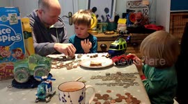 Two boys aged 6 and 3 counting up the money from their money boxes.