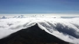 Stunning river of clouds flows over mountain top
