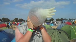 French festivalgoer inflates latex glove on his head!