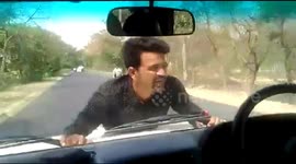 Angry protester clings to official's SUV bonnet for 4km