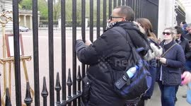 People wait in line outside Buckingham palace to view and photograph the notice board posted by the royal family announcing the birth of the new royal prince