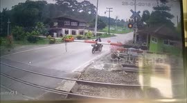 Motorcyclist clotheslined by level crossing moments before train passes