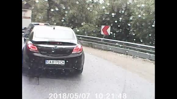 A mad man on the road almost ends up killing the passanger of an incoming vehicle (while trying to overtake a few cars on a turn)