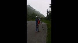 The man caught the big snake while he was carrying his son on the road