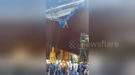 Workers filmed clinging on for life after cargo ship scaffolding collapses