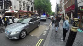 Theresa May escorted down Charing Cross Road