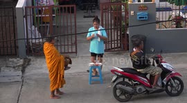 A Thai iBuddhist monk, collects alms.
