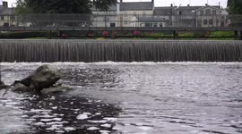 A boat passes by a weir and causes the water to dance.
