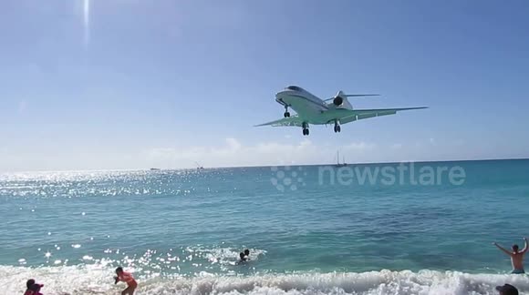 Aircraft flies over tourists' heads at Caribbean beach before airport landing