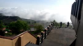 Time-lapse footage of clouds engulfing mountain top