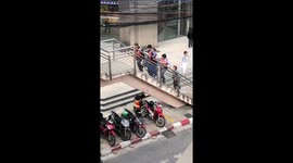 Passers-by lift disabled man in wheelchair up stairs