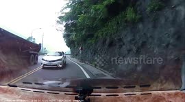 Taiwanese driver narrowly avoids head-on crash with overtaking car on mountain bend