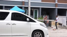 Construction workers in Thailand carry concrete foundation pillars.