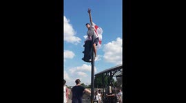 England fan climbs traffic light in London after victory over Sweden