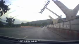 Terrifying moment concrete power post falls onto family's car in Thailand