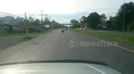 Reckless motorcycle rider stands on seat