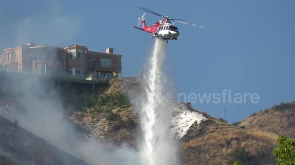 Wildfire season: Fire helicopter does a water drop on a brush fire