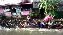 Indian club practices for boat race on flooded road in town