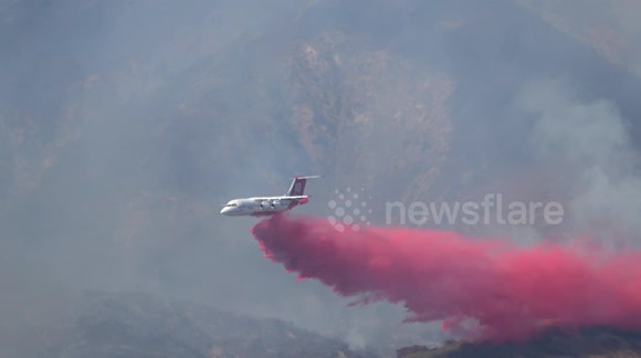 Wildfire: Fire plane drops retardant powder around a wildfire