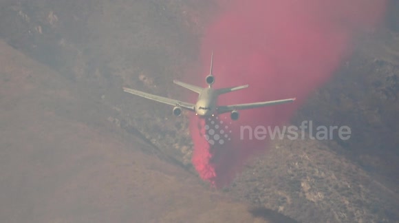 Wildfire: Air Tanker flies through smoke to drop fire retardant