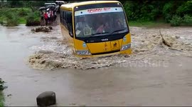 Reckless school bus driver speeds through flooded road in India