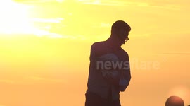 Man holding baby silhouette at sunset