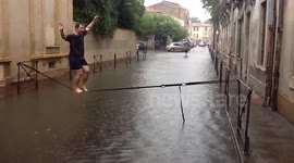Walking a tightrope over a flooded street in Montpellier