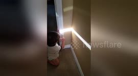 Adorable moment baby discovers his own shadow