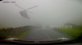 Watch moment chopper almost grazes hillside road in foggy conditions