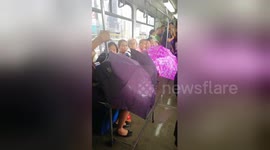 Passengers use umbrellas on leaky train in Philippines after monsoon