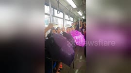Passengers use umbrellas on leaky train in Philippines after monsoon