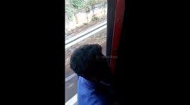 Indian Bus driving with door open and People leaning out