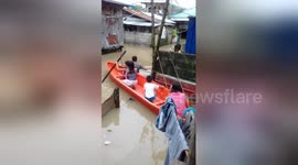 Children use boat to get around village during flooding in the Philippines