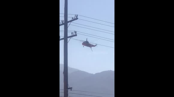 Helicopters continue to load up with water from Corona Lake to put out flare ups from the Holy Fire in the Cleveland National Forest started on August 6 2018 by a human. More than 22,000 acres burned.