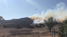 Helicopter conducts water drop on brush fire in Riverside County