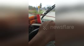 Hilarious moment men use rope to operate broken windscreen wipers in heavy rain