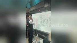 Airport staff update whiteboard as IT troubles continue