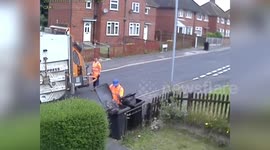 UK bin man takes rubbish out of bin and drops it onto street