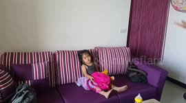 little girl is hitted by the ball..but still steady..ignore the ball..keep watched Tv。。