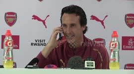 Arsenal boss Unai Emery answers a journalist's phone during press conference