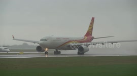 Hainan Airlines takes off from a  flooded runway at Manchester Airport after big downpour