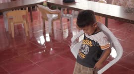 VIDEO ONLY: Schoolboy re-lives moment he put plastic chair on his back like a rucksack