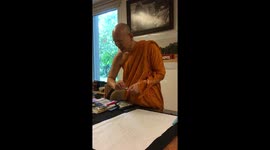 Bhuddhist monk paints picture at temple