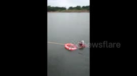 Locals rescue man stuck in the middle of a flooded river