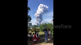 Schoolchildren watch as volcano erupts on quake-hit Indonesia island