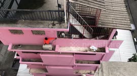 (EXTENDED VERSION) Thai man in flip flops squats on 50ft high narrow ledge to do DIY home repairs