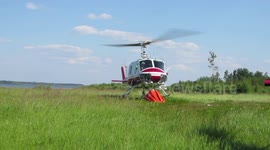 Helicopter taking off with water bucket attached