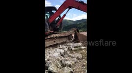 Skilled digger driver uses arm to fix broken machine