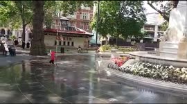 Boy runs around London fountain